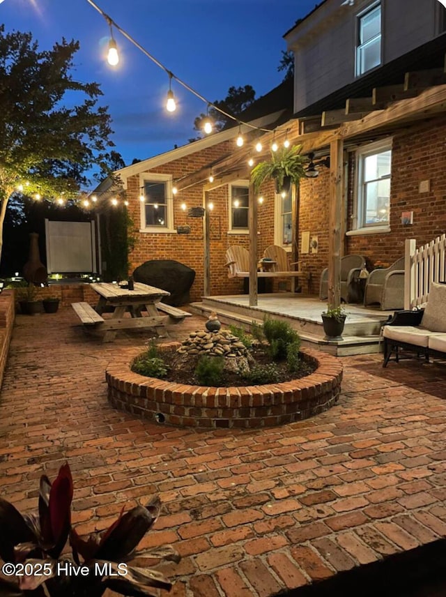 661 Main St, Swansboro, NC 28584 - back of house at night featuring brick siding and a patio