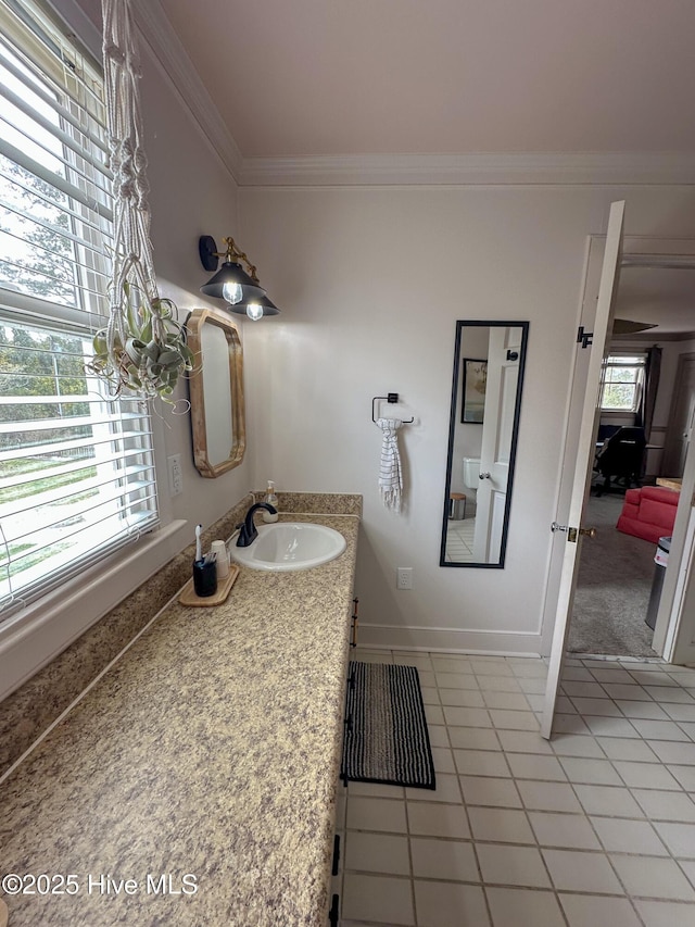 bathroom featuring crown molding, baseboards, tile patterned flooring, and vanity
