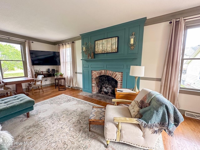 661 Main St, Swansboro, NC 28584 - living area featuring healthy amount of natural light, a fireplace, ornamental molding, wood finished floors, and baseboards