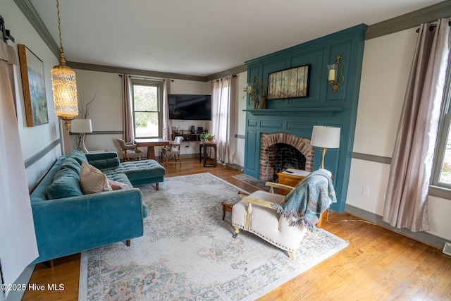 661 Main St, Swansboro, NC 28584 - living room with crown molding, a brick fireplace, and wood finished floors
