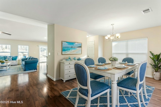 dining space featuring visible vents, baseboards, wood finished floors, and ceiling fan with notable chandelier