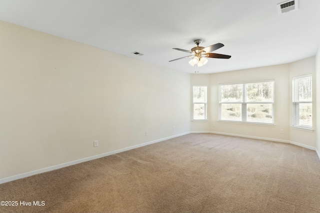 unfurnished room featuring a wealth of natural light, visible vents, and a ceiling fan