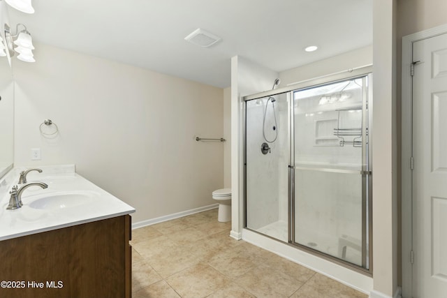 full bath featuring baseboards, double vanity, a stall shower, a sink, and toilet