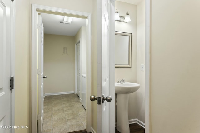 bathroom with a sink, visible vents, and baseboards