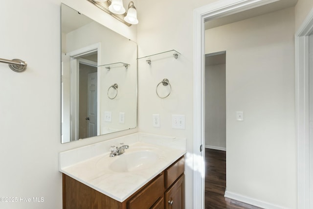 bathroom featuring vanity, baseboards, and wood finished floors