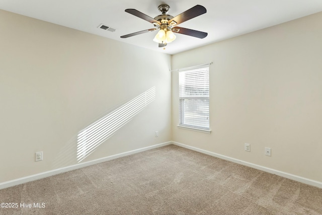 carpeted empty room with visible vents, baseboards, and ceiling fan