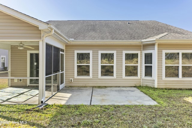 rear view of house with a patio area, roof with shingles, and a sunroom