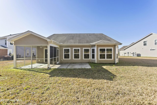 rear view of house featuring roof with shingles, a yard, a sunroom, ceiling fan, and a patio area