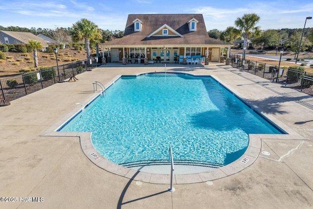 pool with a patio area, fence, and french doors