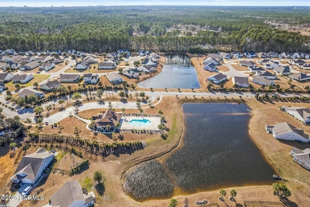 birds eye view of property with a forest view, a water view, and a residential view