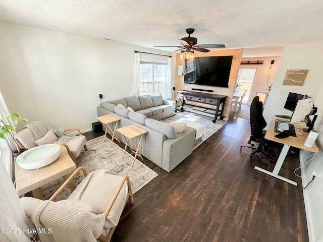 living room with dark wood-type flooring, a healthy amount of sunlight, and a textured ceiling