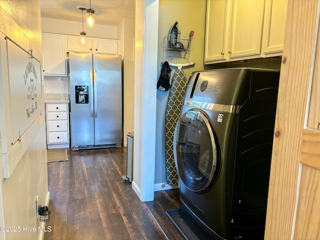 washroom featuring dark wood finished floors, washer / clothes dryer, cabinet space, and baseboards