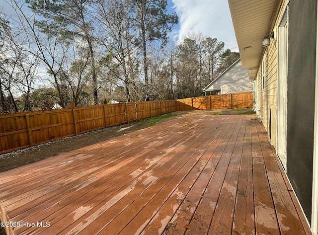 wooden deck with a fenced backyard