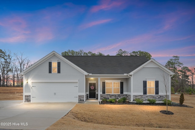 view of front of home featuring a garage, stone siding, driveway, and a shingled roof