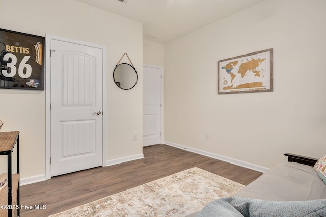 sitting room with baseboards and wood finished floors