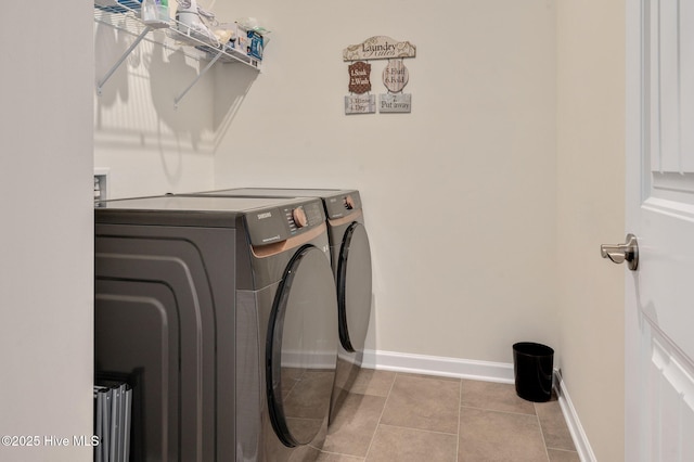 laundry area with washer and dryer, baseboards, laundry area, and tile patterned flooring