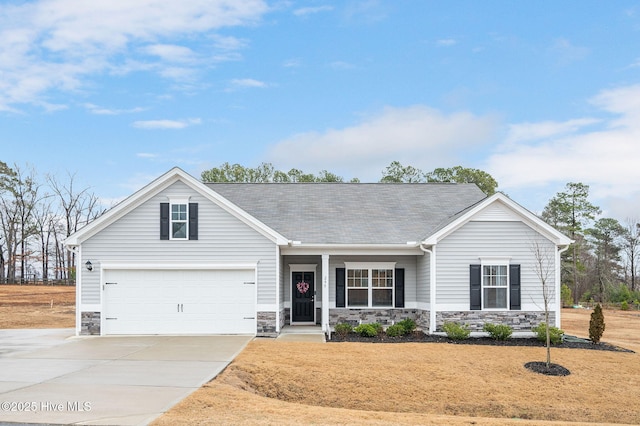 view of front of house featuring stone siding, an attached garage, concrete driveway, and a shingled roof