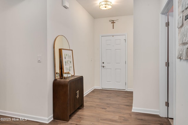 foyer featuring baseboards and wood finished floors