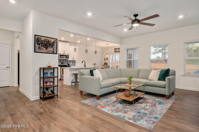 living room featuring wood finished floors, recessed lighting, a ceiling fan, and baseboards