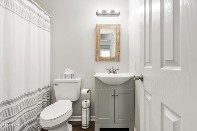 bathroom with vanity, toilet, and baseboards