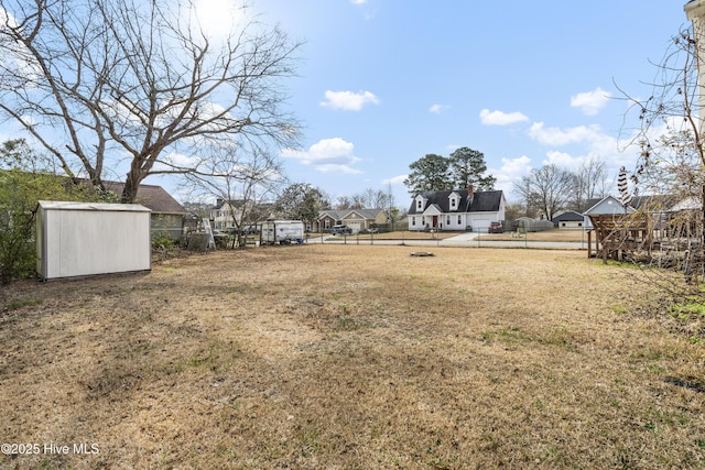 view of yard with an outdoor structure, a storage unit, and fence