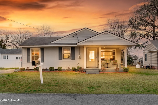 view of front of house with a porch, a front lawn, and a shingled roof