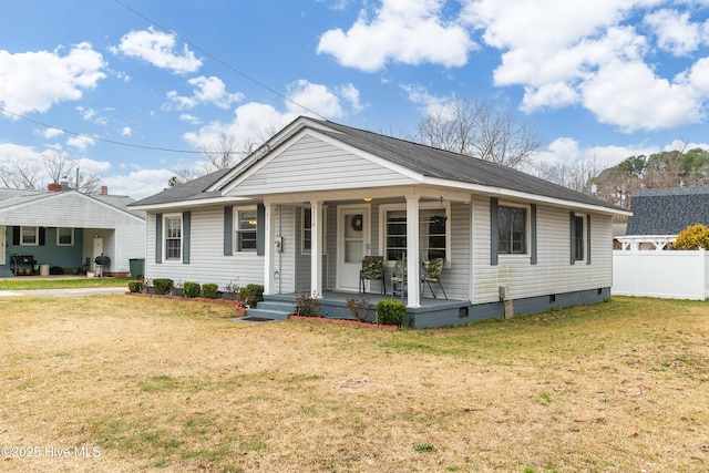 bungalow with a porch, fence, a front lawn, and crawl space