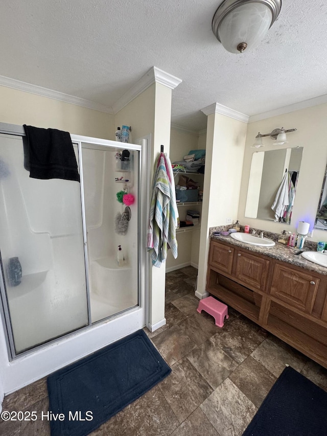 bathroom featuring vanity, a textured ceiling, a stall shower, and ornamental molding