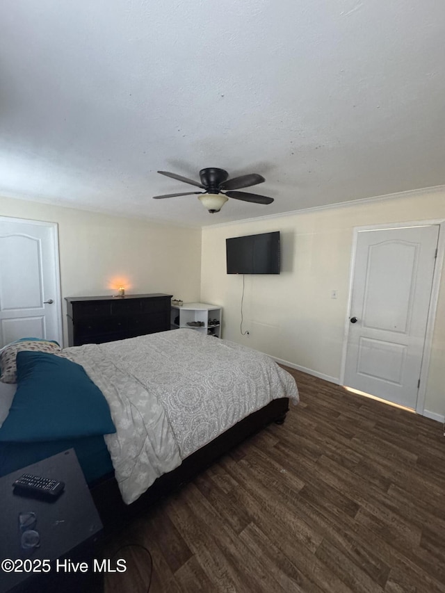 bedroom with baseboards, a ceiling fan, and dark wood-style flooring