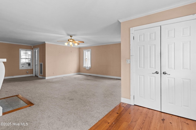 unfurnished living room featuring baseboards, plenty of natural light, ceiling fan, and crown molding