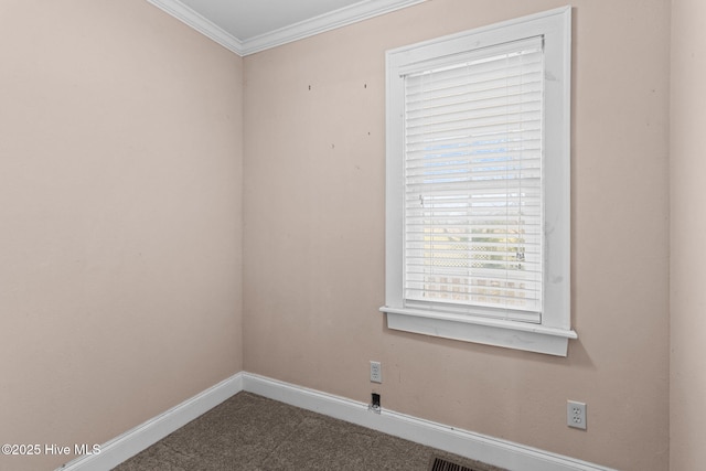 spare room with baseboards, carpet, and crown molding