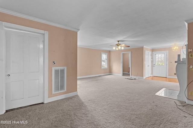 unfurnished room featuring visible vents, a healthy amount of sunlight, carpet, and ornamental molding