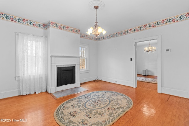 living area featuring a fireplace, wood finished floors, and a chandelier