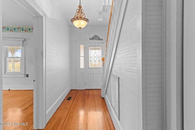 doorway to outside with visible vents, light wood-type flooring, and baseboards