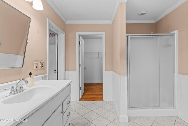 bathroom with tile patterned floors, wainscoting, vanity, and a shower stall