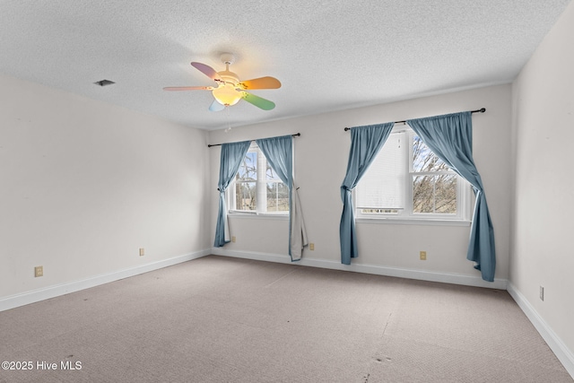 empty room featuring baseboards, a textured ceiling, a ceiling fan, and carpet