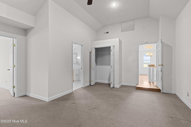 unfurnished bedroom with connected bathroom, baseboards, carpet, and high vaulted ceiling