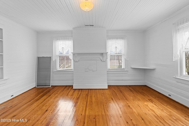 empty room with hardwood / wood-style flooring, a healthy amount of sunlight, and baseboards