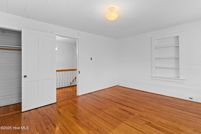 unfurnished bedroom with wood finished floors and a closet