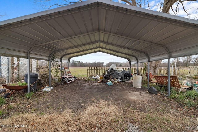 view of parking / parking lot with a carport and fence