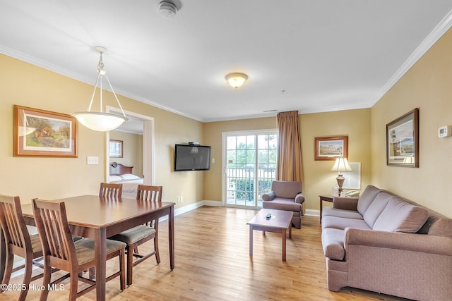 dining area with baseboards, light wood-style floors, and crown molding