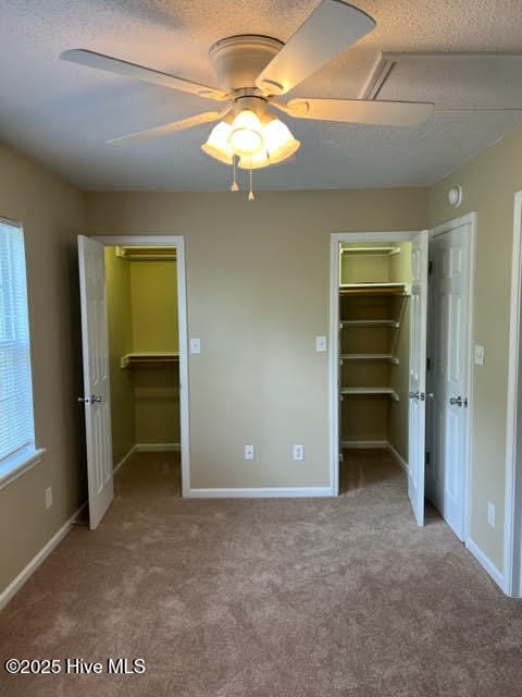 unfurnished bedroom featuring a closet, a textured ceiling, and a spacious closet