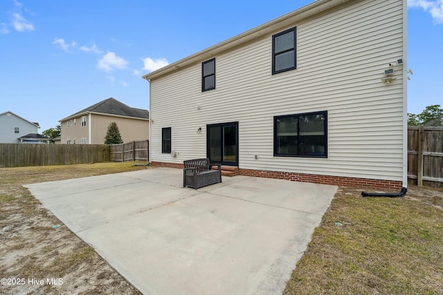 back of property with a yard, a patio area, and a fenced backyard