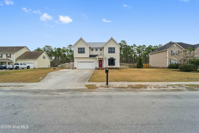 traditional-style home with concrete driveway, metal roof, a front lawn, and fence