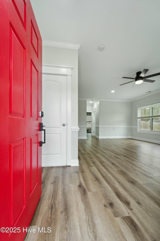 entryway with baseboards, crown molding, ceiling fan, and wood finished floors