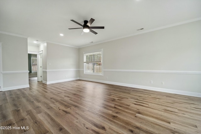 unfurnished room featuring visible vents, baseboards, wood finished floors, and a ceiling fan