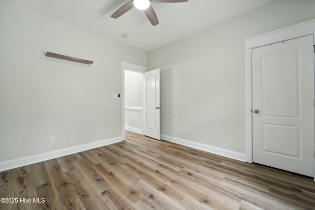 unfurnished bedroom with ceiling fan, baseboards, and wood finished floors