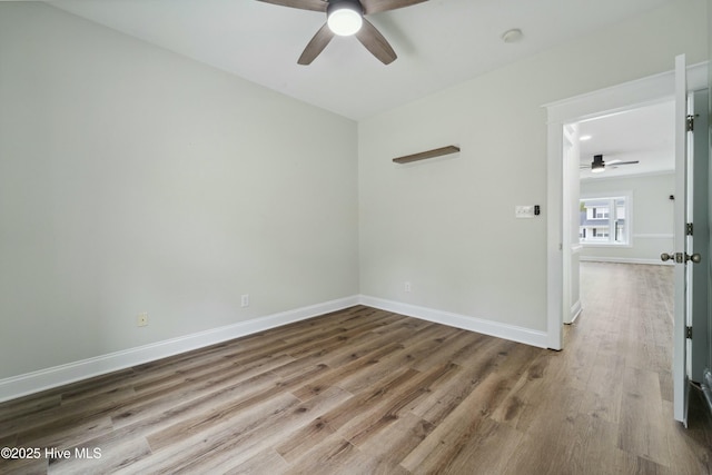 unfurnished room with wood finished floors, baseboards, and ceiling fan