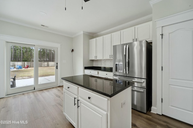 kitchen featuring decorative backsplash, wood finished floors, crown molding, and stainless steel fridge with ice dispenser