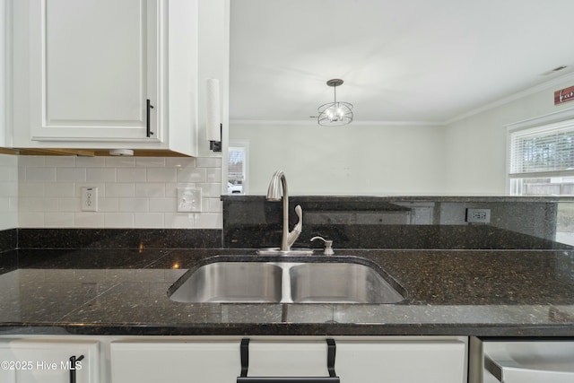 kitchen with tasteful backsplash, ornamental molding, dishwashing machine, white cabinets, and a sink